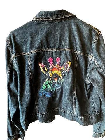 large jeans jacket decorated with machine embroidered giraffe in rainbow colors